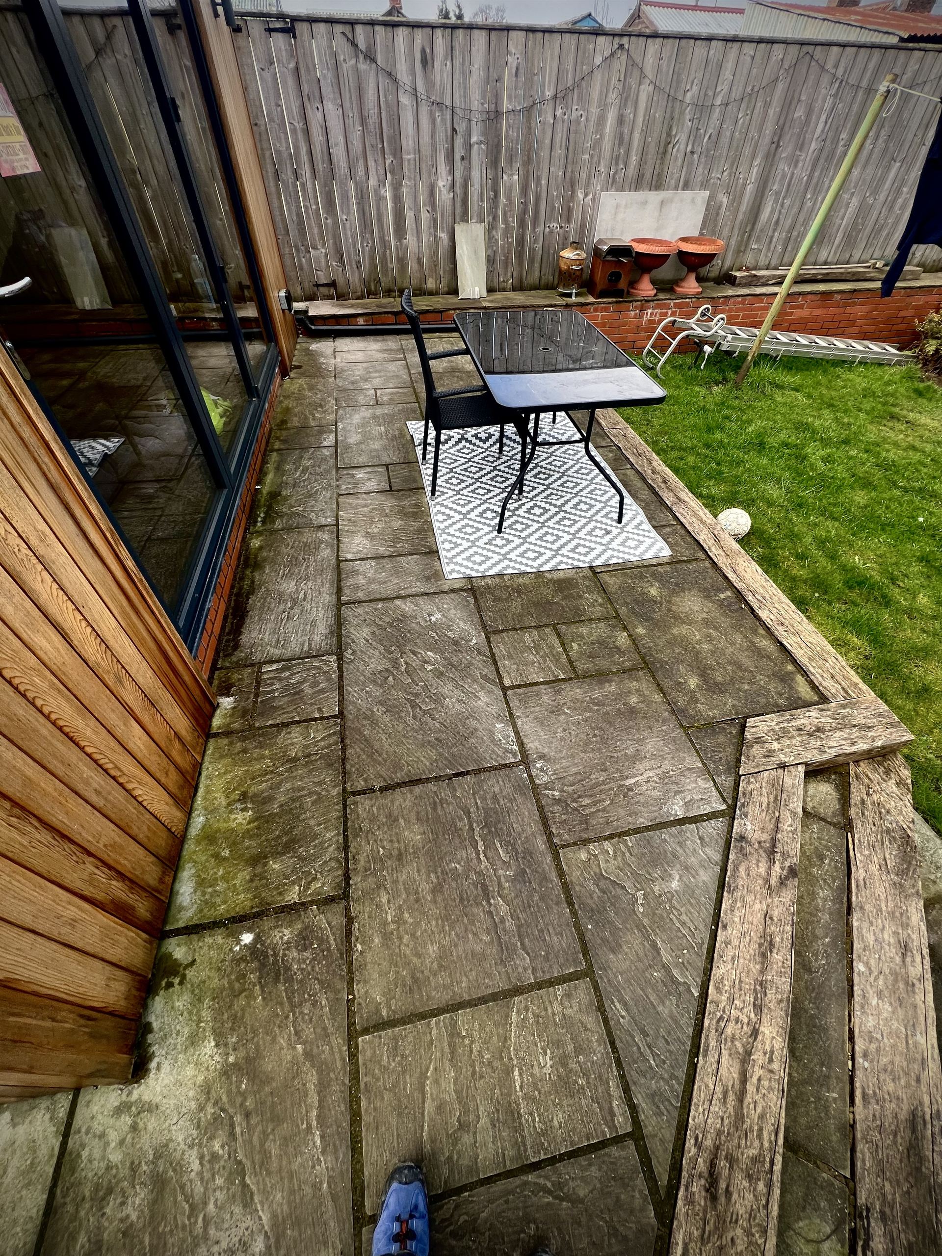 Indian sandstone patio in Ryedale before professional cleaning - covered in moss